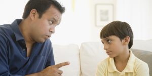 Hispanic father lecturing son